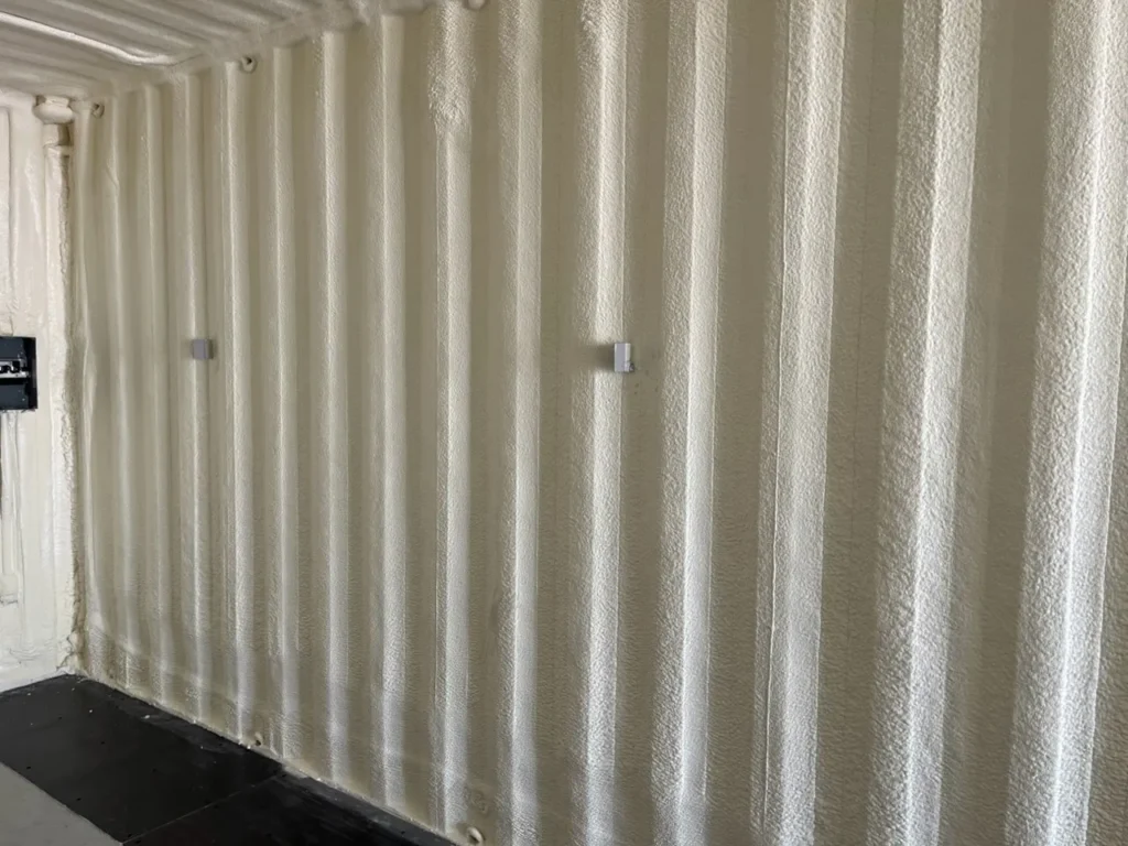 Closed cell foam sprayed on a corrugated steel wall