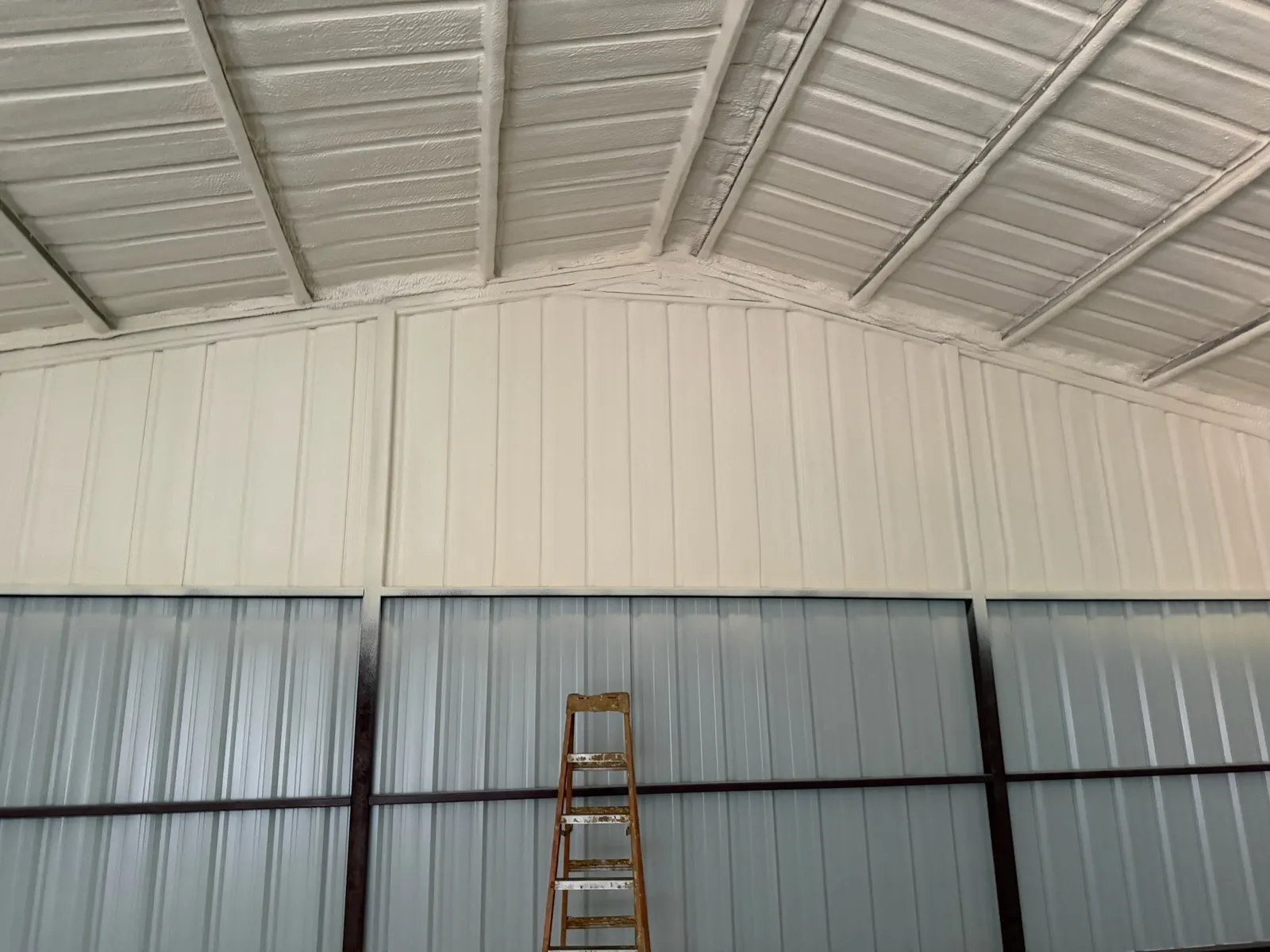 Metal building ceiling and walls coated in spray foam